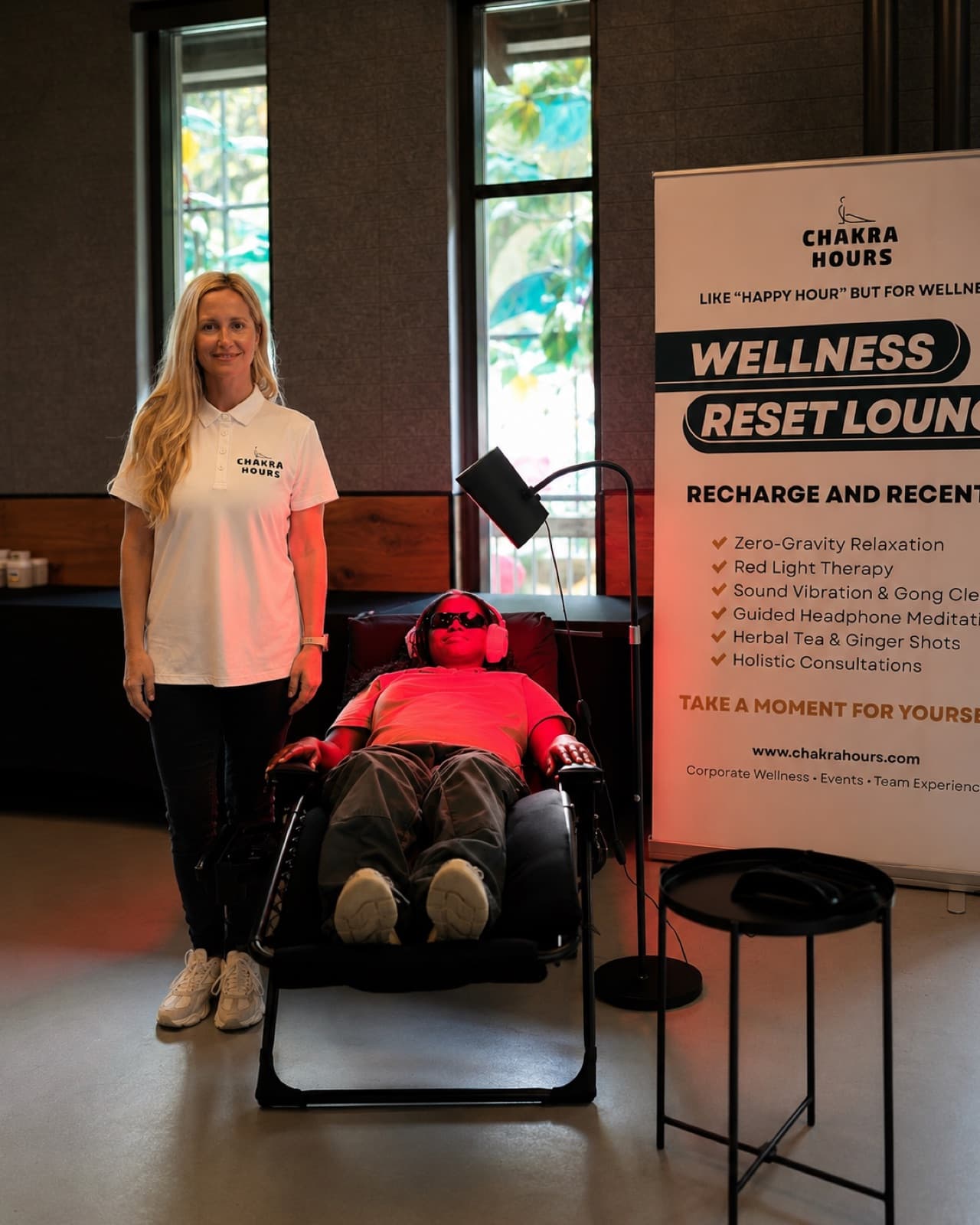 A guest reclining in a zero-gravity chair with red-light goggles and headphones during a Chakra Hours Wellness Reset Lounge in Dallas, Chakra Hours