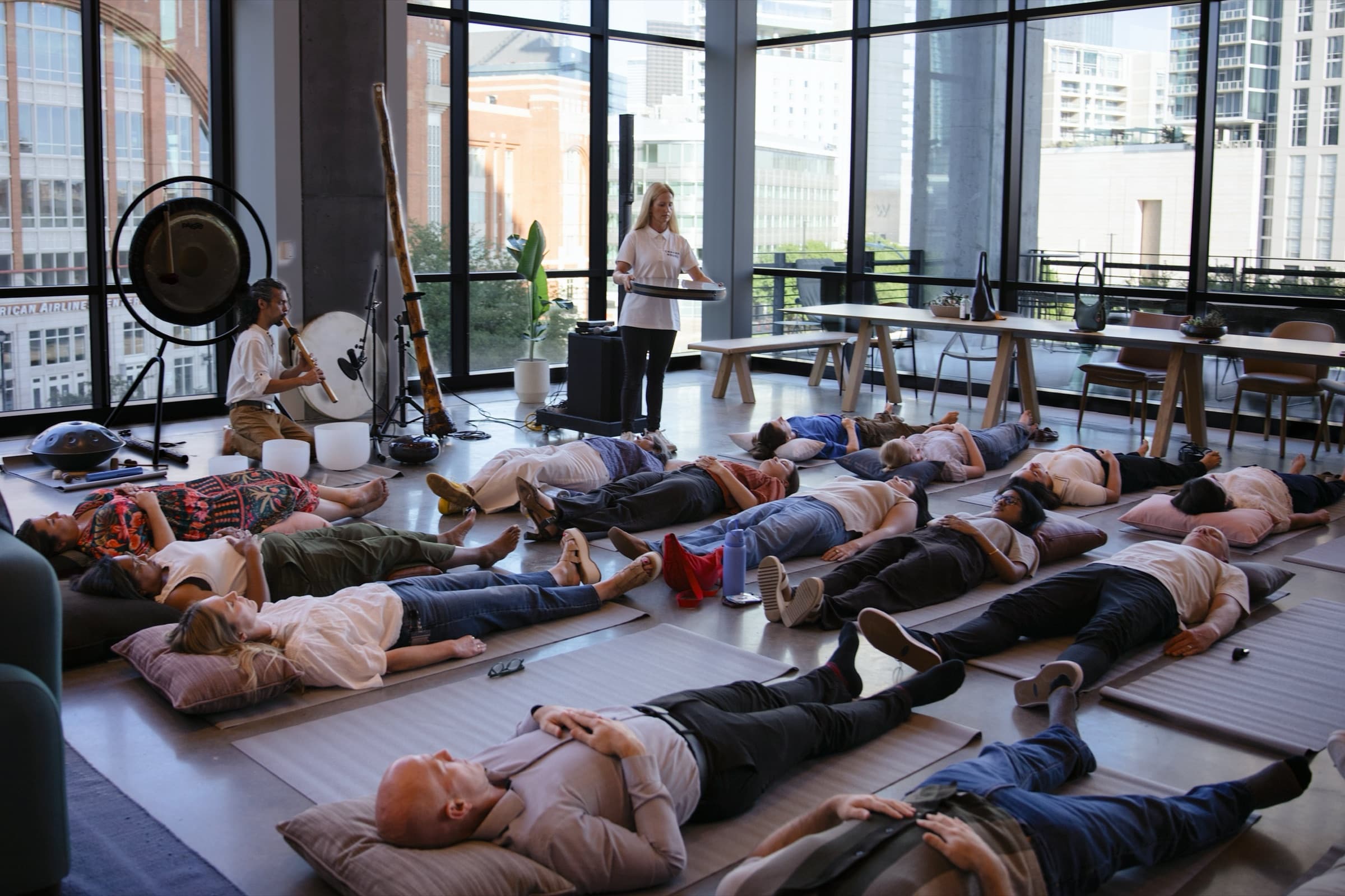 A facilitator playing crystal bowls during a live corporate sound bath — health fair ideas for employees — Chakra Hours