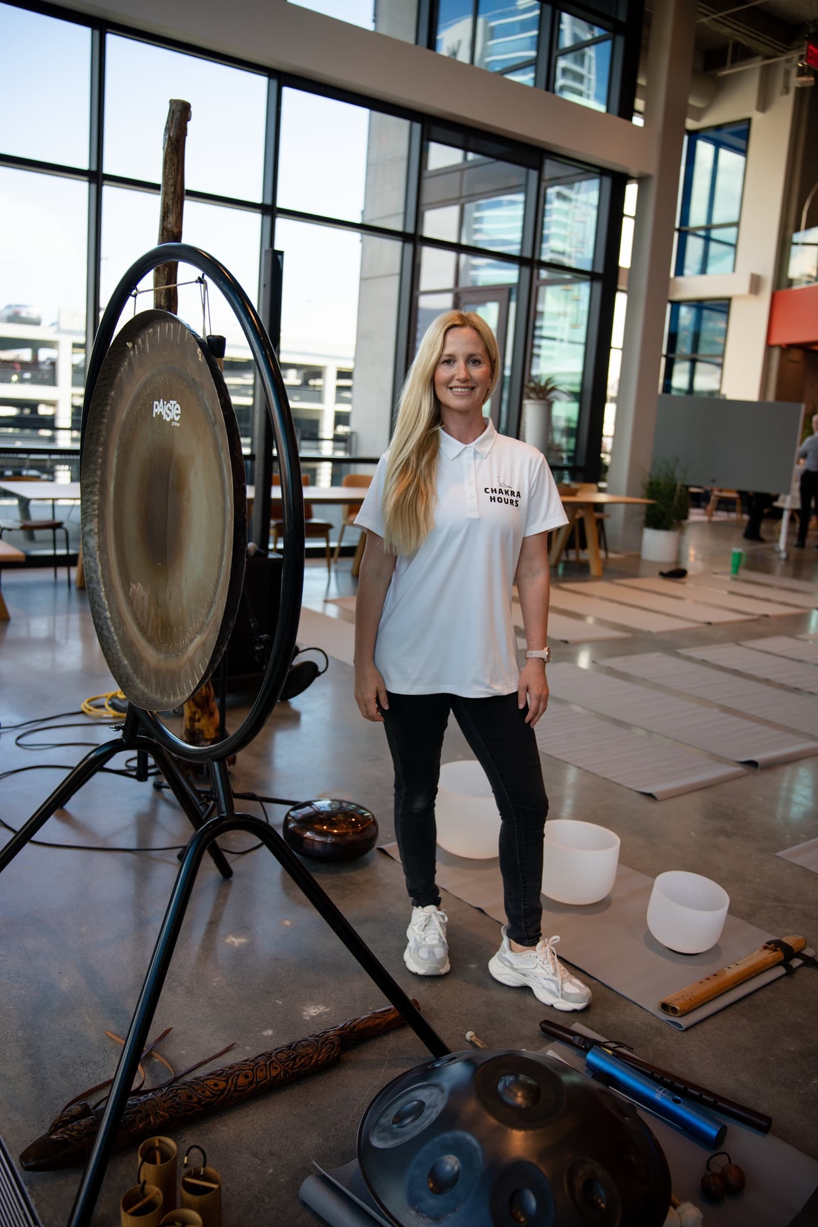 Nina Mua, creator of The Workday Reset Method, with the gong, crystal bowls, and handpan before an onsite session in Dallas, Chakra Hours