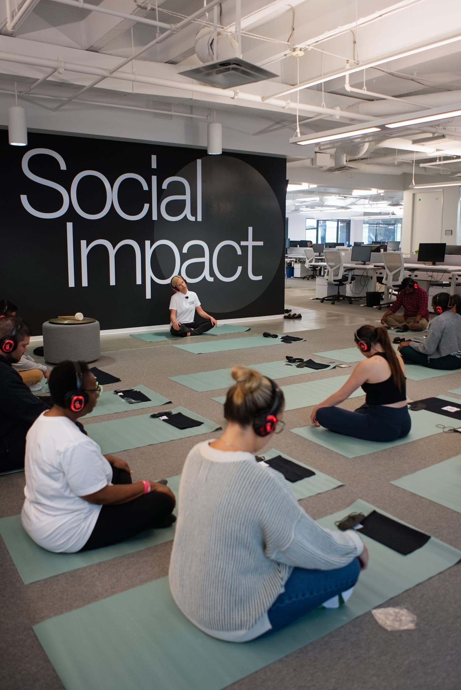 A Chakra Hours facilitator leading a group wellbeing session for employees at a Dallas client office — corporate health fair vendors — Chakra Hours